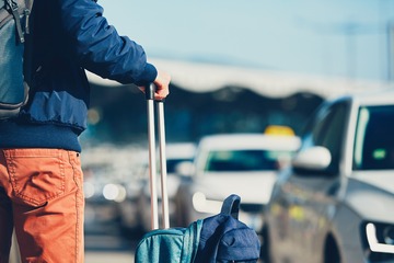 Homme avec une valise qui attend un taxi